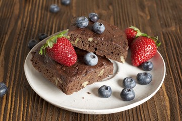 Chocolate - cherry brownie served with blueberry and strawberry 