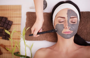 Young woman in beauty salon having face mask