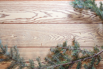 Christmas card background with a space for text on a wooden surface and decorated with fir branches
