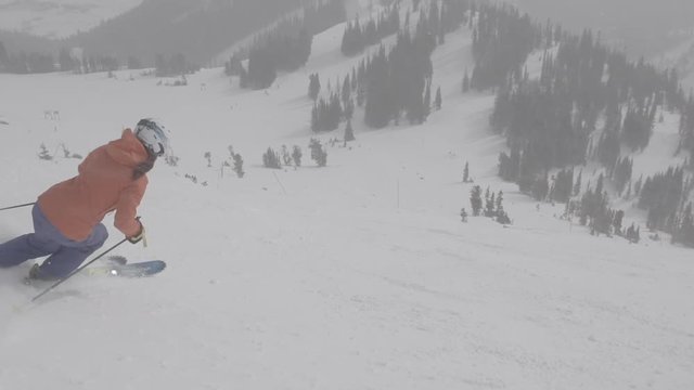 Woman skis down wide open bowl in winter wonderland