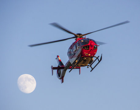 Helicopter with an almost full moon