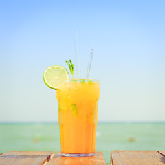 Mango mojito on the wooden pier. Concept of luxury tropical vaca