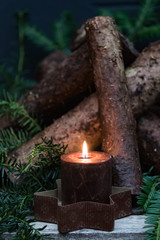 Fototapeta na wymiar Advent candle with firewood and fir sprigs