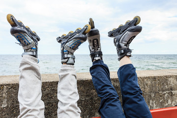Closeup of people friends with roller skates.