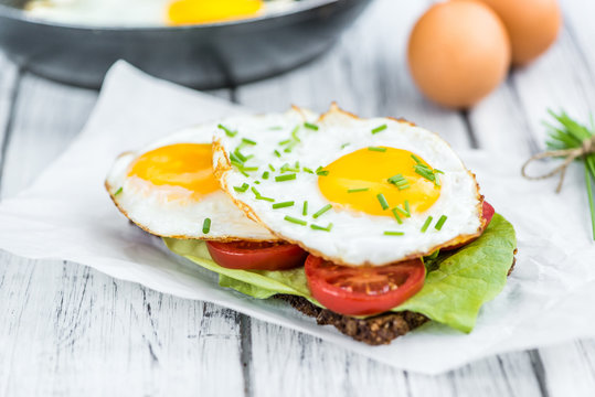 Wooden table with Fried Eggs (on a Sandwich)