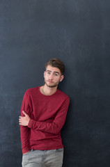 Trendy relaxed young man with a modern haircut standing against