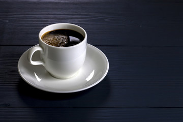 Cup of coffee on the wooden table in blue