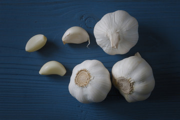 garlic bulbs with garlic cloves  on blue wooden background