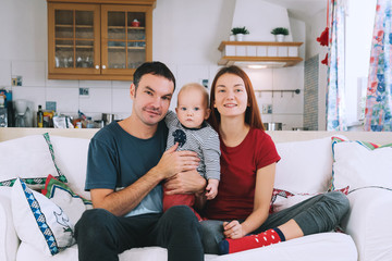 A young playful family at home on the couch.