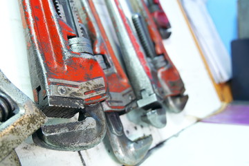 Red pipe wrench hung in storage.