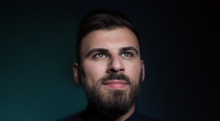 Attractive business man on dark studio background.