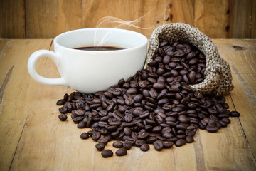 Hot coffee on the wood and roast coffee bean.