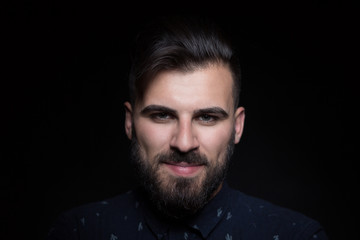 Fototapeta premium Portrait of handsome man wearing black shirt, black background,