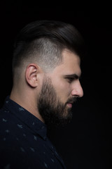 low key portrait of young handsome man in dark shirt  isolated o