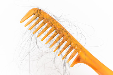 Hair loss problem, Closeup of a hairbrush with hair fall on white background.