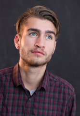 Portrait of a fashionable young man on dark background, chalkboa