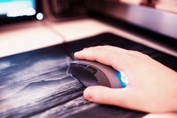 Computer mouse with human hand on mousepad bokeh backdrop