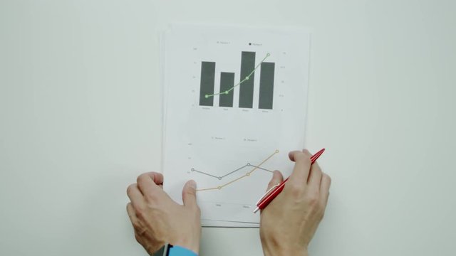 Businessman comparing graphic charts.
