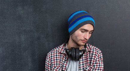 Handsome DJ posing in studio on dark background with headphones