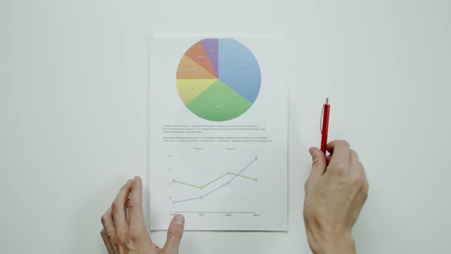 Male hands hold graphic charts.