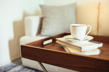 Fototapeta na wymiar Pillow on sofa Home Interior Coffee cup Books on table wooden tray table