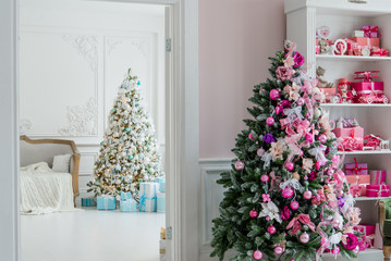 Interior room decorated in Christmas style. No people. An empty green chair. Pink colors. Home comfort of modern house.