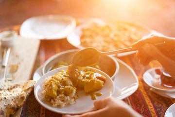 Woman puts food on a plate, sunny