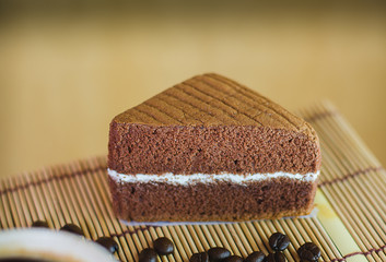 A cup of coffee with slice of chocolate cake on White background