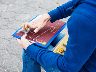 The girl draws with pastel crayon. Drawing on the board.