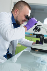 Obraz premium Young scientist investigating microbiological substance in micro