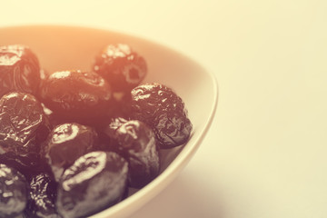 Small plate with black dates on a white background. Toned
