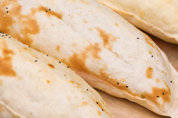 Fresh ruddy pies sprinkled with sesame seeds