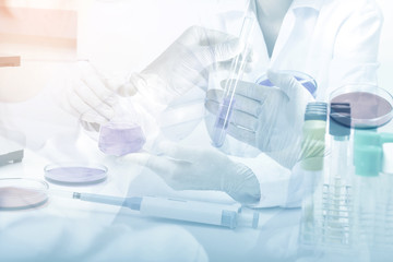  Double exposure of  science experiment hand holding test tube i