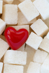 Cubes of sugar with a red heart, background