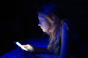 young women using the smart phone on bed before sleep