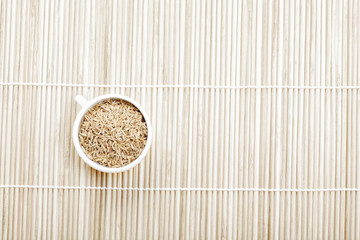 Caraway spice seeds in cup on mat