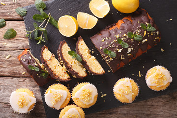 Sliced lemon cake with chocolate and lemon muffins with icing and zest close-up. horizontal top view 
