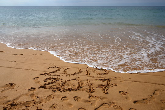 turn of the year/ numbers written in the sand denoting the turn of the year