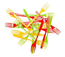 Pile colorful plastic forks closeup isolated on white background.