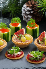 Set of festive Christmas mini appetizers on dark background