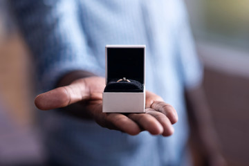 Close up of engagement ring held by African man