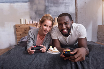 International couple playing games on console together