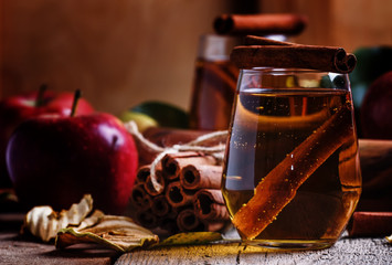 Fototapeta na wymiar Apple cider with cinnamon, vintage wooden background, selective