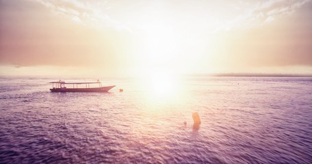 Naklejka na ściany i meble Sunset over a bay with fishing boat