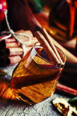 Apple cider with cinnamon, vintage wooden background, selective