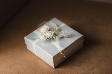 present gift box and artificial flowers on fabric