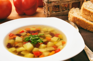 Transparent vegetarian soup with bean and vegetables.