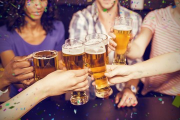 Composite image of happy friends drinking beer and toasting