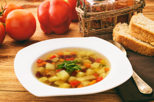 Transparent vegetarian soup with bean and vegetables.