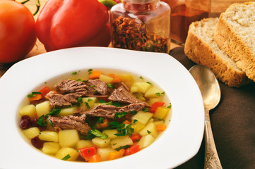 Transparent meat soup with bean and vegetables.